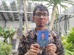 Dedi-saat-memegang-foto-mendiang-adiknya-Lettu-Laut-Kesehatan1.jpg