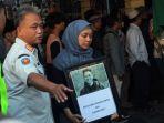 Foto-keluarga-membawa-foto-almarhum-Arya-Daru-Pangayunan.jpg