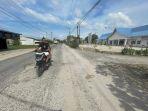 JALAN-RUSAK-Pengendara-sepeda-motor-melintas.jpg