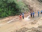 Petugas-membersihkan-material-longsor-yang-menutup-jalan-lintas-Langkat-Karo_1.jpg