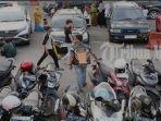Petugas-parkir-meminta-retribusi-parkir-kepada-pengendara-roda-dua.jpg