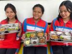 Sejumlah-siswa-di-Kota-Medan-saat-menunjukkan-menu-MBG.jpg