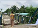 Seorang-anak-terlihat-berjalan-di-atas-jembatan-yang-roboh_Desa-Bandar-Setia_.jpg