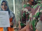 Sri-Rejeki-kiri-menunjukan-surat-permohonan-menuntut-keadilan.jpg