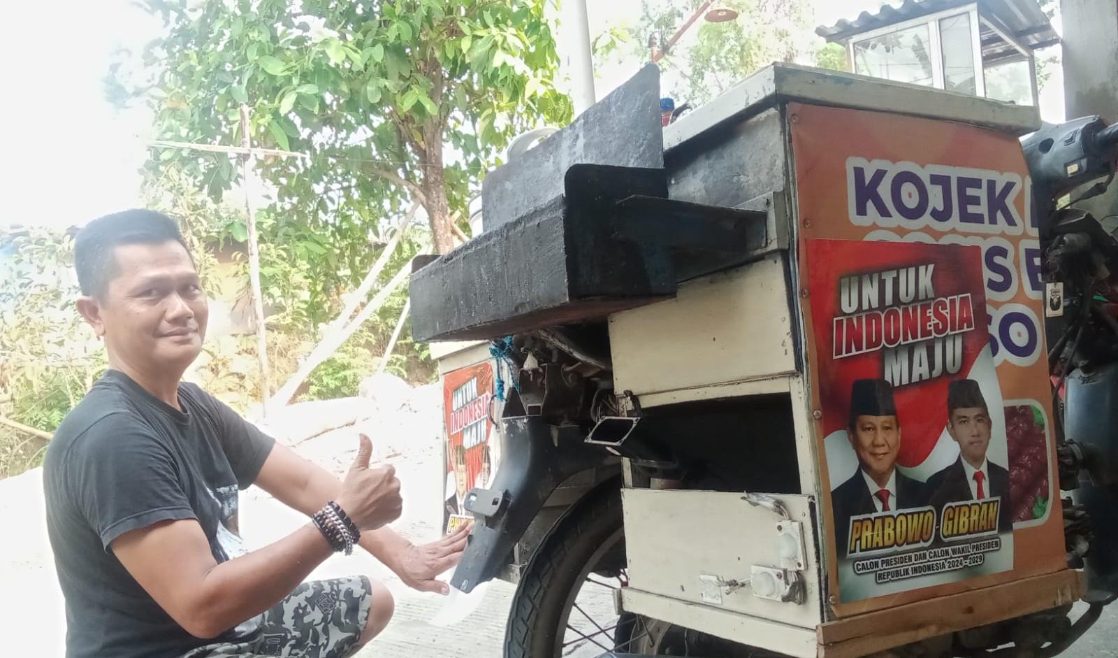 pedagang-kojek-keliling-menunjukkan-gerobak-bergambar-pasangan-Prabowo-Gibran.jpg