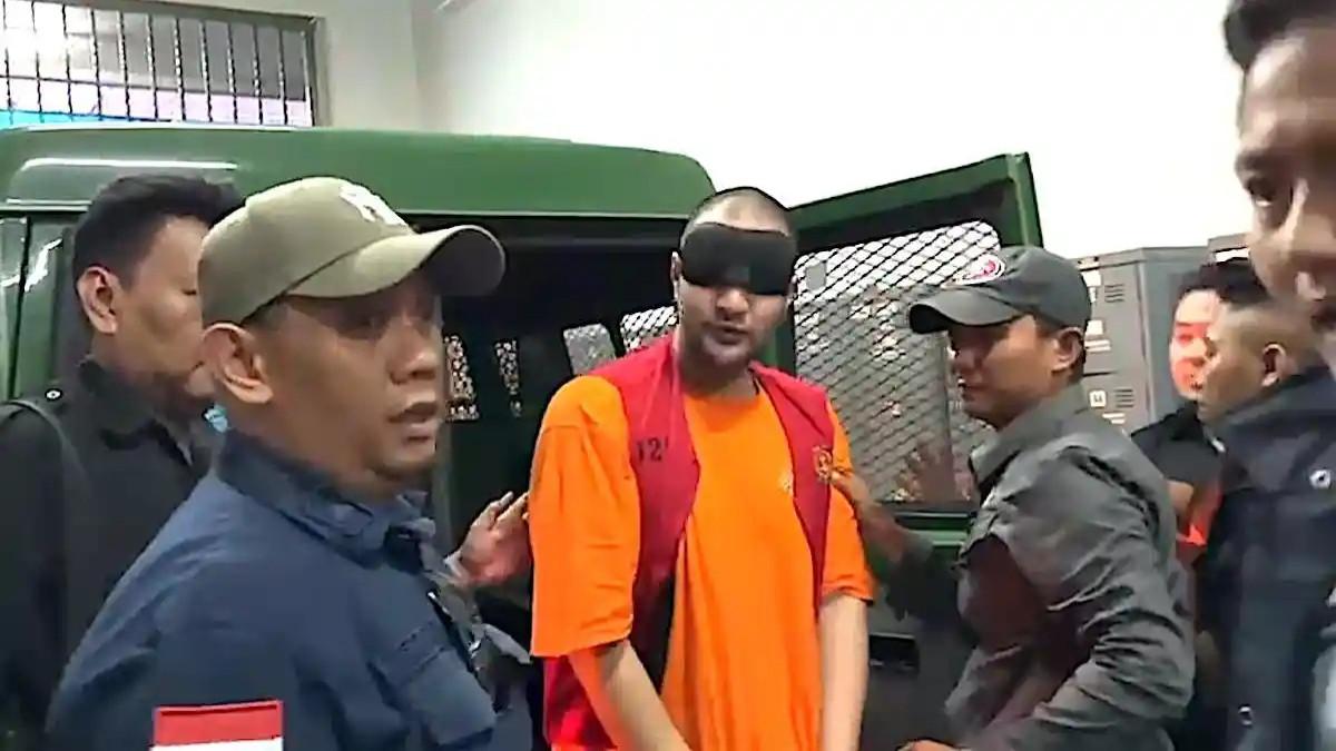 AMMAR ZONI DIPINDAH - Ammar Zoni dan kawan-kawan tiba di Lapas Cipinang, Jakarta Timur mengendarai mobil tahanan warna hijau dengan pengawalan aparat gabungan. Ia mengenakan kaos oranye dan rampi tahanan Lapas Cipinang dengan kondisi tangan diborgol serta mata ditutup, Sabtu (13/12/2025)