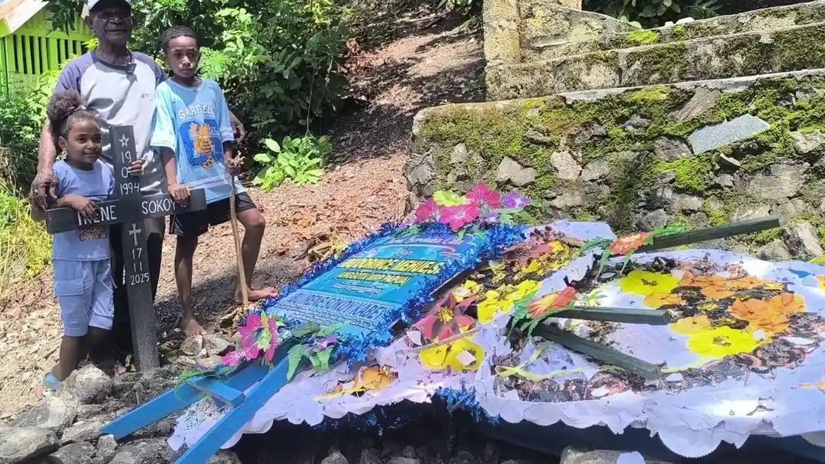 DITOLAK RS -- Abraham Kabey dan kedua cucu (anak Irene Sokoy) saat berdiri di makam Irene Sokoy