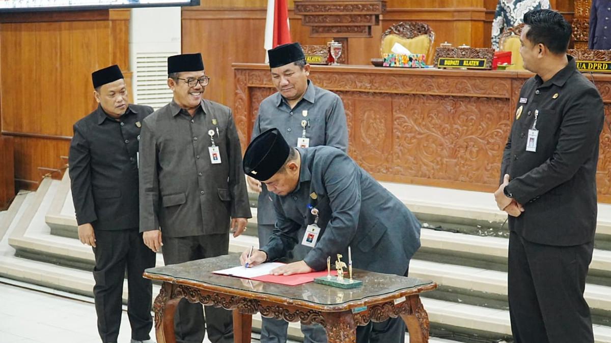 RAPAT DPRD KLATEN - Ketua DPRD Klaten Edy Sasongko menandatangani dokumen pengesahan Raperda di Gedung Paripurna DPRD Klaten, Senin (17/11/2025) malam.