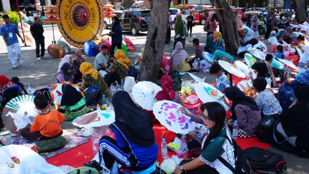LOMBA LUKIS PAYUNG - Ratusan pelajar duduk rapi di bawah tenda, sibuk melukis saat Lomba Lukis Payung yang diselenggarakan Disbudporapar Klaten di halaman Gedung Sunan Pandanaran Klaten, Kamis (16/10/2025).