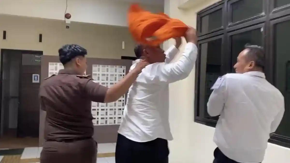 HINDARI SOROTAN KAMERA - Terdakwa AKBP Basuki diduga menghindari sorotan kamera dengan menutup wajah menggunakan rompi tahanan oranye, dan sempat mengibaskannya ke arah kuasa hukum keluarga korban, seusai sidang di Pengadilan Negeri Semarang, Senin (4/5/2026). Dia merupakan terdakwa dalam kasus kematian dosen Untag Semarang, Dwinanda Linchia Levi, yang sidang pembacaan tuntutannya kembali ditunda dan dijadwalkan ulang.