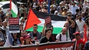 Orang-orang-membentangkan-spanduk-dan-mengibarkan-bendera-nasional-Palestina.jpg