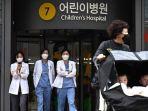 Petugas-medis-berjalan-di-luar-rumah-sakit-anak-di-Seoul-Korea-Selatan-pada-11-Maret-2024.jpg