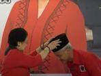 momen-megawati-memberikan-dan-memakaikan-kopiah-ke-ganjar-pranowo.jpg