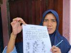 rita-andri-pratama-kakak-perempuan-sepri-menunjukkan-selembar-surat-pemberitahuan-dalam-mandarin.jpg