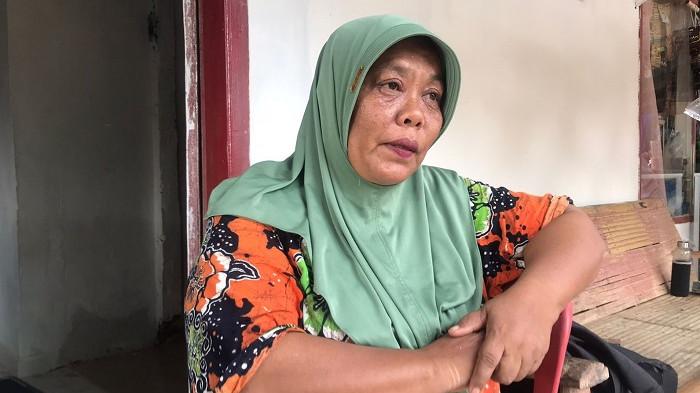 Asinar terisak saat mengenang perjuangan sandjir bandang menghantam rumahnya.