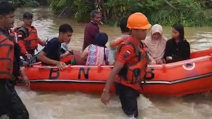 BANJIR PADANG PARIAMAN - Petugas membantu evakuasi warga korban banjir di Nagari Kampuang Galapung, Kabupaten Padang Pariaman, Sumatera Barat, Senin (24/11/2025).