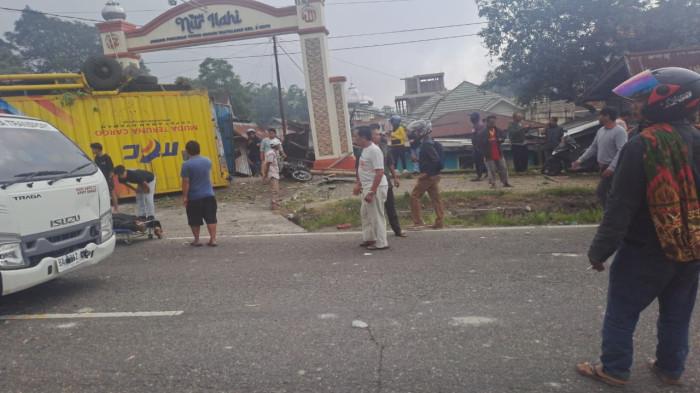 KECELAKAAN BERUNTUN - Warga menyaksikan kondisi sebuah truk yang terbalik dan menabrak bangunan di kawasan Panyalaian, Kecamatan Sepuluh Koto, Kabupaten Tanah Datar, Sumatera Barat, Senin (26/1/2026). Insiden ini sempat menghebohkan pengguna jalan dan warga sekitar lokasi kejadian.