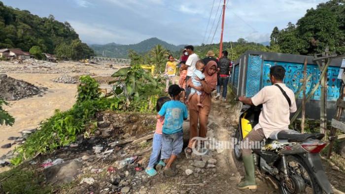 JALAN PUTUS: Derasnya aliran Sungai Batang Kuranji, atau yang lebih dikenal warga sebagai Sungai Batu Busuk, mengakibatkan putusnya akses utama yang menghubungkan Kelurahan Kapalo Koto dengan Kelurahan Lambung Bukit, Kecamatan Pauh, Kota Padang. Hingga Minggu (4/1/2026), warga terpaksa melintasi jalur darurat yang sempit dan berisiko demi menjaga mobilitas.