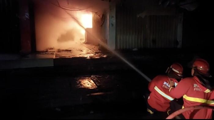 KEBAKARAN: Petugas Dinas Pemadam Kebakaran Kota Padang berusaha memadamkan api yang membakar deretan toko di Blok A Pasar Raya Padang, Kamis (30/10/2025) dini hari. Api berhasil dipadamkan setelah tiga jam upaya pemadaman.