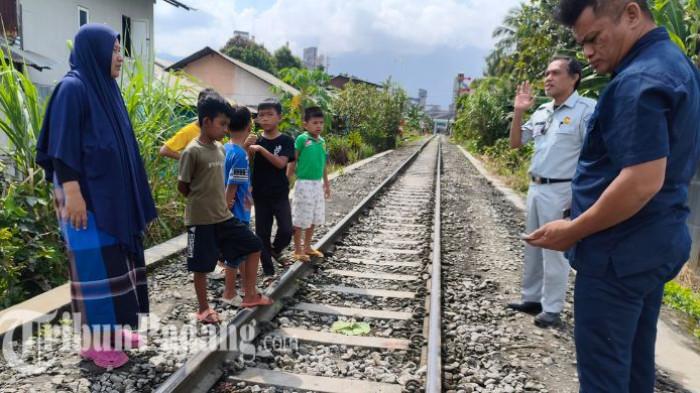 KORBAN TERTABRAK KERETA - Warga sekitar, Ernawati saat menunjukkan lokasi kecelakaan buruh asal Cilacap kepada TribunPadang.com di perumahaan Fakrisindo, Limau Manis Selatan, Kecamatan Pauh, Kota Padang, Rabu (25/3/2026). Sisa darah dan daun talas untuk menutup jasad korban masih tertinggal di lokasi kecelakaan.