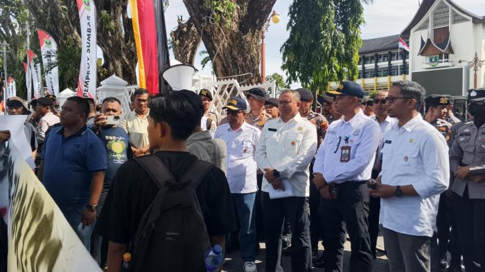 AKSI DEMO- Belasan massa yang tergabung dalam Kelompok Komunitas Masyarakat Banjir Bandang Sumbar menggelar aksi unjuk rasa di depan Kantor Gubernur Sumbar, Rabu (3/6/2026). Dalam aksi tersebut, massa menyampaikan sejumlah tuntutan, mulai dari pengusutan praktik illegal logging dan illegal mining hingga percepatan pencairan dana revitalisasi pascabencana banjir bandang 2025.