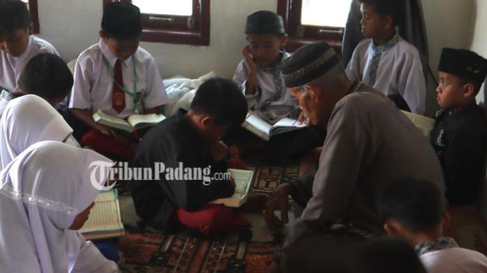 PASCA BANJIR PADANG: Anak-anak Madrasah Diniyah Takmiliyah Awaliyah (MDTA) Surau Jamiaturrahmah belajar mengaji di rumah warga Kelurahan Lambung Bukik, Kecamatan Pauh, Kota Padang, Selasa (21/1/2026).  Pantauan di lokasi pada Selasa (20/1/2026), area yang dulunya merupakan pusat pendidikan agama itu kini hanya berupa hamparan puing.