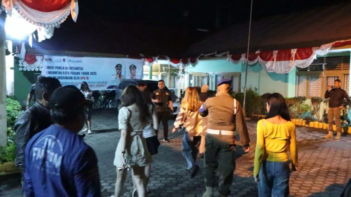 PENERTIBAN JAM OPERASIONAL- Petugas Satpol PP Padang mengamankan sejumlah perempuan dari tempat hiburan malam yang melanggar jam operasional di kawasan Padang Barat, Minggu (7/9/2025). Mereka dibawa ke Mako Satpol PP untuk dimintai keterangan lebih lanjut.