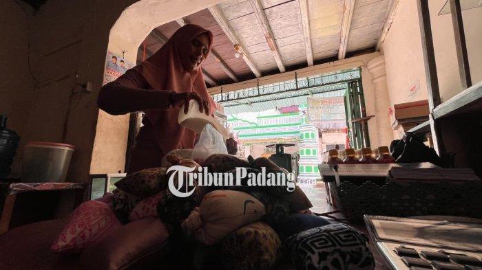 TRADISI SERAK GULO- Seorang warga keturunan india Faradillah Yunus (47), sedang membungkus gula pasir di Pasa Batipuah, Pasa Gadang, Padang Selatan, Kota Padang, Jumat (14/11/2025). Gula ini berasal dari hasil penyisihan rezeki warga yang dipercayakan padanya untuk dibagikan saat hari puncak tradisi serak gulo pekan depan. 