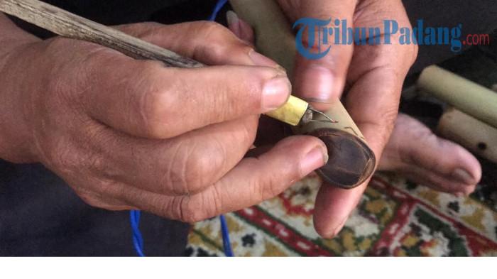 UKIRAN- Feri sedang mengukir bansi