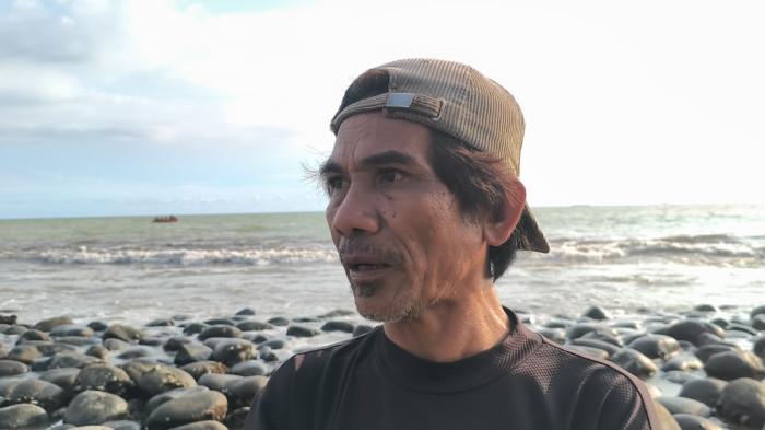 PENCARIAN ORANG HILANG - Warga, Jon Lewer, memberikan keterangan di Pantai Ujung Karang, belakang kampus UBH, Kecamatan Padang Utara, Kota Padang, Rabu (22/4/2026). Jon menduga dua korban tersangkut di material kayu sisa banjir yang ada di dalam laut.