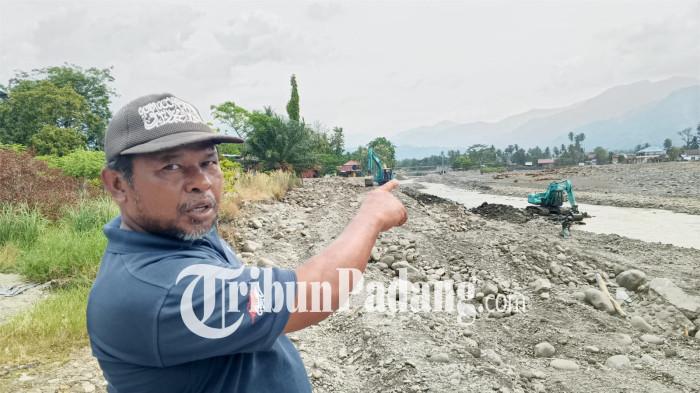 PASCABANJIR BANDANG- Muhammad Zen (43), warga Kelurahan Koto Pulai, Kecamatan Koto Tangah, Kota Padang, melihat perubahan alur sungai di sekitar Bendungan Koto Tuo, Kelurahan Koto Panjang Ikua Koto (KPIK), Selasa (27/1/2026). Perubahan arus sungai tersebut terjadi pascabanjir bandang November 2025 dan kini semakin mendekati permukiman warga.
