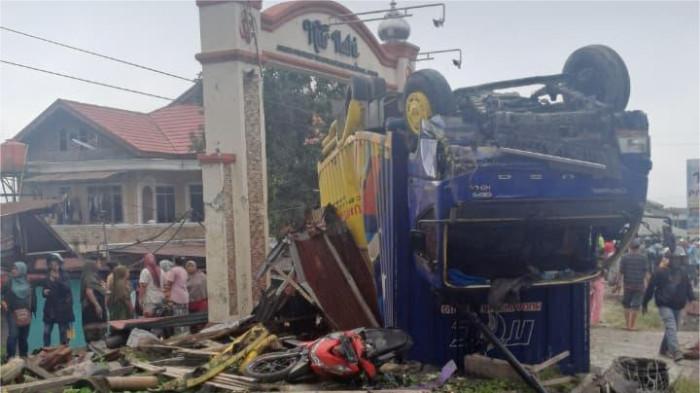 KECELAKAAN BERUNTUN– Warga menyaksikan kondisi sebuah truk yang terbalik dan menabrak bangunan di kawasan Panyalaian, Kecamatan Sepuluh Koto, Kabupaten Tanah Datar, Sumatera Barat, Senin (26/1/2026). Kecelakaan beruntun yang diduga dipicu rem blong tersebut melibatkan sejumlah kendaraan dan menyebabkan kerusakan parah di lokasi kejadian.