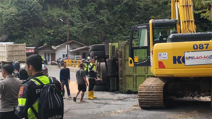 KECELAKAAN TUNGGAL- Sejumlah petugas kepolisian dan alat berat yang sedang bekerja untuk mengevakuasi truk yang mengalami kecelakan di Lubuk Paraku, Jumat (27/2/2026). Truk bermuatan batu bara tersebut mengalami kecelakaan diduga karena rem blong.