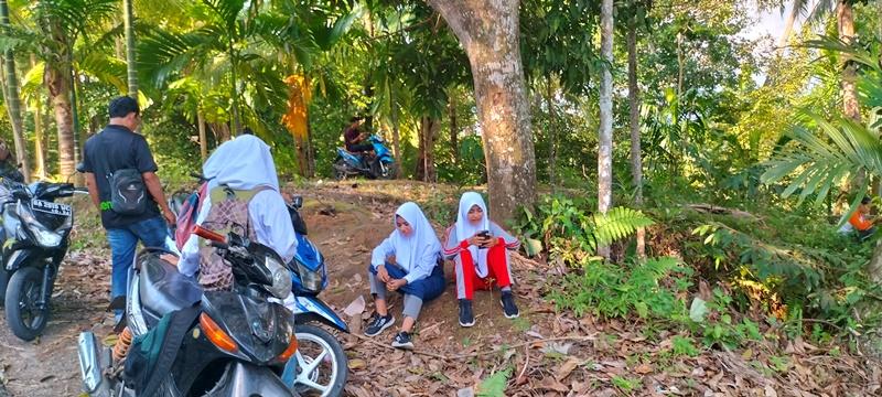 Empat-orang-siswa-sedang-sibuk-menggunakan-telepon-pintar-mereka-di-Jalan-Batu-Gadang.jpg