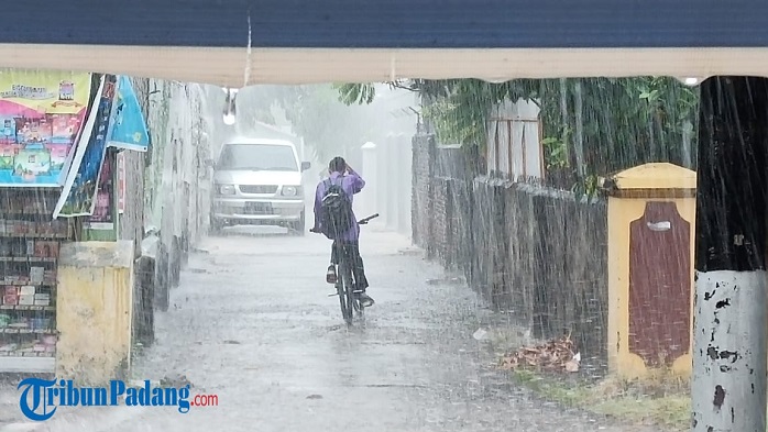 seorang-remaja-mengayuh-sepeda-saat-hujan-turun.jpg