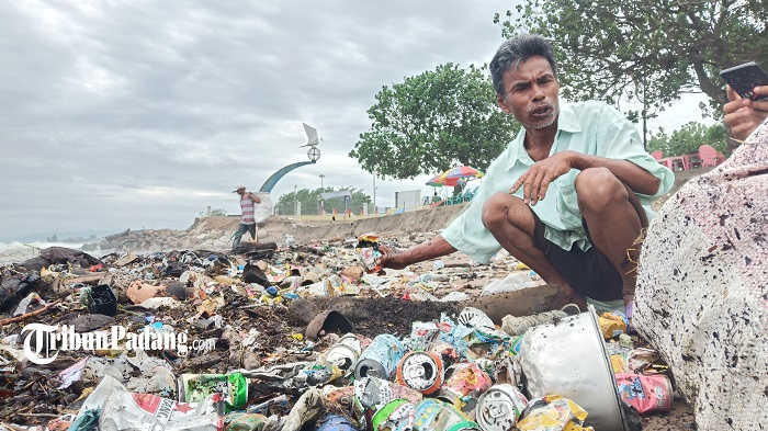 seorang-warga-saat-sedang-memilih-sampah-minuman-kaleng-di-kawasan-pantai-muaro-lasak.jpg