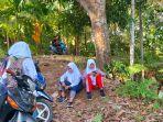 Empat-orang-siswa-sedang-sibuk-menggunakan-telepon-pintar-mereka-di-Jalan-Batu-Gadang.jpg