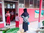 Fitri-Wati-saat-mengantarkan-anaknya-sampai-ke-depan-pintu-kelas.jpg