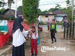 Guru-SDN-29-saat-sedang-memeriksa-suhu-badan-muridnya.jpg