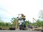 Seorang-warga-melintasi-jembatan-penghubung-dua-kecamatan.jpg