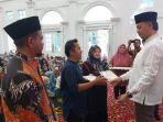 Wako-Erman-Safar-saat-menyerahkan-bantuan-pendidikan-kepada-PNS.jpg