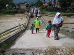 warga-melewati-jembatan-yang-rusak-akibat-banjir-di-solok-selatan-jumat-22112019.jpg