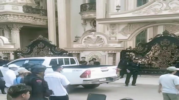 RUMAH MEWAH - Polisi bersenjata berjaga-jaga di sekitar rumah mewah milik Haji Sutar di Desa Tulung Selapan Kabupaten Ogan Ilir Sumatera Selatan.