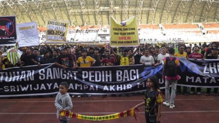SUPORTER DUDUKI LAPANGAN - Ribuan suporter Sriwijaya FC turun ke lapangan hijau Stadion Gelora Sriwijaya Jakabaring Palembang pasca Sumsel United mengalahkan Sriwijaya FC dengan skor 5-0 pada  Derby Sumsel Pegadaian Championship 2025-2026 antara Sumsel United melawan Sriwijaya FC, Sabtu (24/1/2026). SYAHRUL HIDAYAT