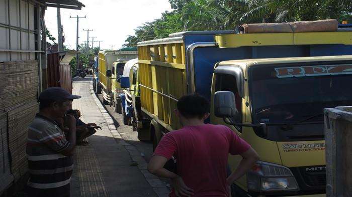 NUNGGU ANTRE SOLAR --- Sejumlah sopir truk duduk di trotoar sembari menunggu antrean solar di  SPBU Jalan Singadekane, Sabtu (22/11/2025). Aturan baru solar tidak dijual pada siang hari di dalam Kota Palembang dan sejumlah SPBU tidak jual solar, terpaksa mereka berburu SPBU jual solar pada siang hari di pinggiran kota. Mereka keluhkan jam istirahat tidak ada lagi. SYAHRUL HIDAYAT