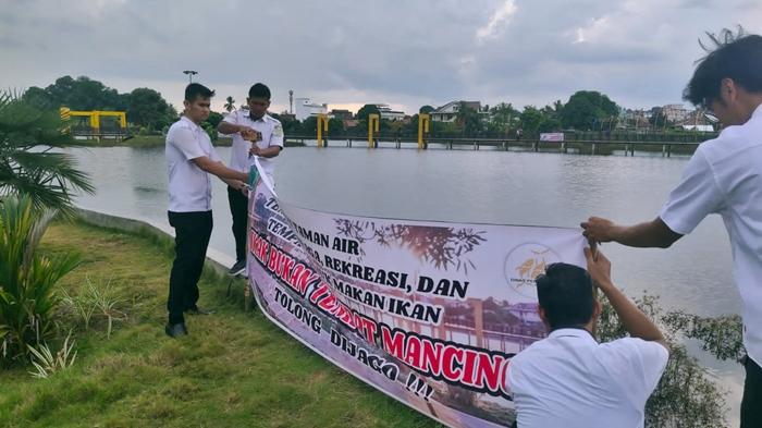 Dinas-Perikanan-Muba-ketika-memasang-spanduk-larangan-memancing-pada-Taman-Air-Serasan-Sekate.jpg