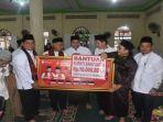 Bupati-Banyuasin-H-Askolani-menyerahkan-bantuan-uang-ke-masjid.jpg