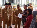 Bupati-Muratara-Devi-Suhartoni-saat-menyerahkan-bantuan-secara-simbolis-kepada-korban-kebakaran.jpg