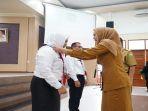 Kepala-BPDSDMD-Provinsi-Sumsel-Hj-Tarbiyah-SPd-memasangkan-tanda-peserta-diklat.jpg