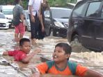 Diguyur Hujan Dua Jam Jalan KM 7 Jadi Kolam Renang Anak-anak